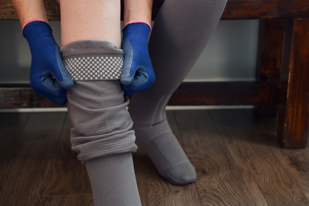 woman-putting-on-compression-stockings-using-donni-2023-11-27-05-37-03-utc.jpg